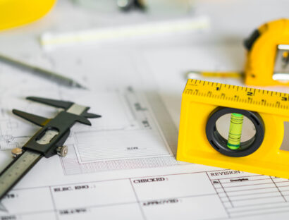 Construction plans with helmet and drawing tools on blueprints
